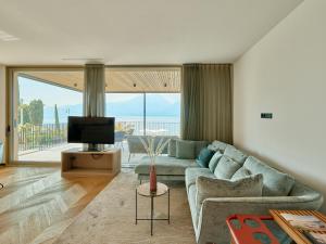 a living room with a couch and a television at Apartment La Baia in Torri del Benaco