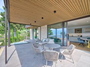 an open patio with a table and chairs at Apartment La Baia in Torri del Benaco