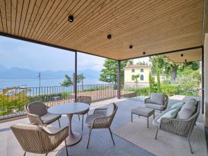 a patio with a table and chairs and a view of the ocean at Apartment La Baia in Torri del Benaco