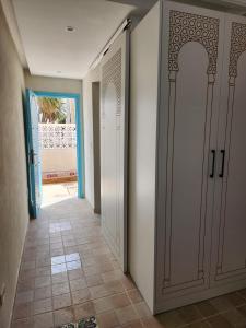a hallway with two white doors and a tile floor at Houch traditionnelle in Houmt Souk +24 photos