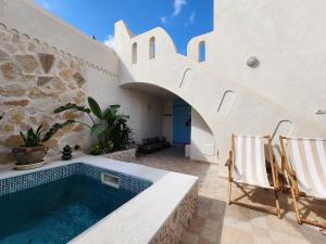 a swimming pool in the middle of a house at Houch traditionnelle in Houmt Souk