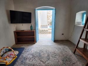 a room with a blue door and a television at Houch traditionnelle in Houmt Souk
