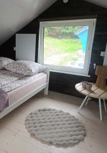 a bedroom with a bed and a window and a rug at Domki Ale Góry Beskid Żywiecki Korbielów in Korbielów