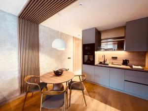 a kitchen and dining room with a wooden table and chairs at Apartman 206 in Jahorina