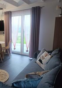 a living room with a couch and a large window at Domki Ale Góry Beskid Żywiecki Korbielów in Korbielów