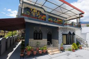 a house with potted plants on the balcony at Mona's Villa Homestay in Dharmsāla