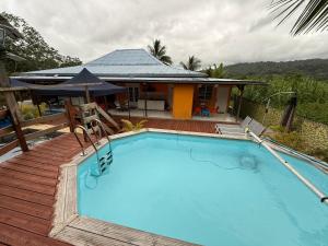 a swimming pool in front of a house at Kaz Gwayav Dous in Gros-Morne