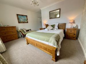 a bedroom with a bed and a chair in it at Ashburton Court Guest House in Ashburton