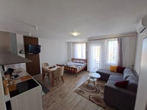 a living room with a couch and a table at City Center Studio Apartment in Prizren