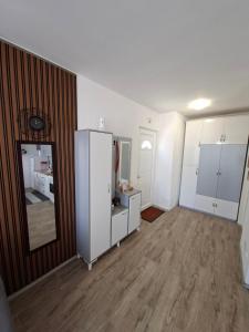 a living room with white cabinets and a wooden floor at City Center Studio Apartment in Prizren