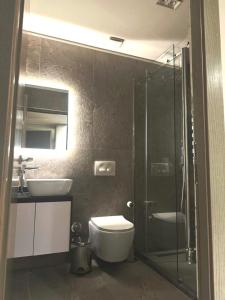 a bathroom with a toilet and a sink and a shower at Hotel EIBA in Peshkopi