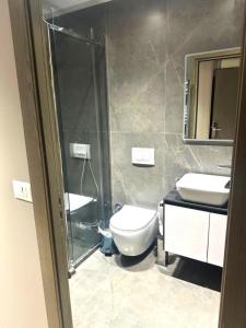 a bathroom with a shower and a toilet and a sink at Hotel EIBA in Peshkopi +14 photos