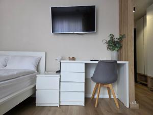 a bedroom with a desk and a bed and a chair at Central Urban Studio with Underground Parking in Târgu-Mureş