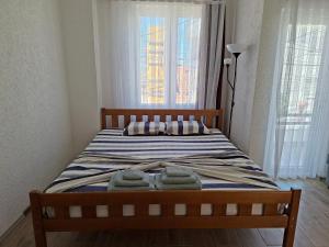 a bedroom with a bed with two towels on it at City Center Studio Apartment in Prizren
