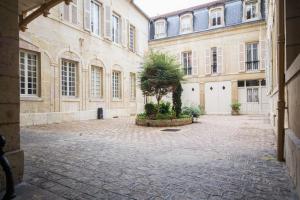 un patio en un edificio con un árbol en el medio en Le Loisy en Dijon