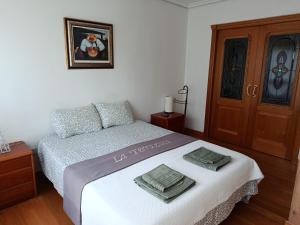 a bedroom with a bed with two towels on it at La Terrazuca in Santander