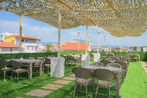 a group of tables and chairs under a tent at Noa Hotel Velipoje in Velipojë