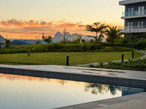a pool of water in front of a building at Spacious 2-Bedroom Family Suite with Pool & Garden View in Moka