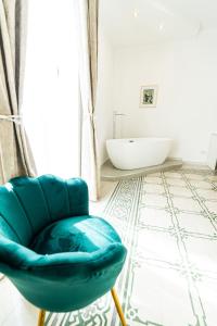 a bathroom with a blue chair and a tub at Palazzo Sorge - Sicilian Charm in Balestrate +63 photos