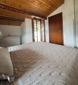 a large bed in a bedroom with a wooden ceiling at da rifare 1 in Solto Collina
