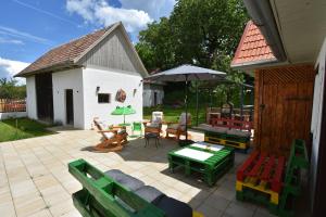 a patio with chairs and tables and an umbrella at Green Escape-Entire House in Moldoveneşti