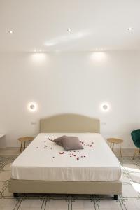 a bedroom with a bed with red rose petals on it at Palazzo Sorge - Sicilian Charm in Balestrate