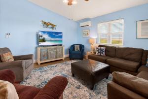 a living room with a couch and a tv at Spacious & Pet Friendly - Game Room Sleeps 10 in Port Aransas