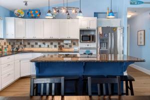a kitchen with white cabinets and a blue island at Spacious & Pet Friendly - Game Room Sleeps 10 in Port Aransas +39 photos