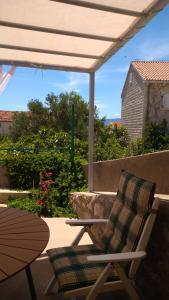 a rocking chair and a table on a patio at Studio apartman Marija in Bol