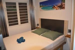 a bedroom with a bed with a blue hat on it at Kaz Gwayav Dous in Gros-Morne +59 photos