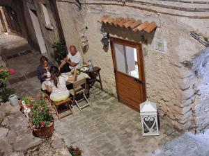 a group of people sitting at a table outside a building at TRE METR SOPRA IL CIELO ''AcquAria'' in Felitto