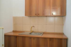 a kitchen counter with a sink and wooden cabinets at Noa Hotel Velipoje in Velipojë +31 photos