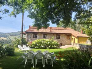 a table and chairs in front of a house at Casa vacacional Valles Pasiegos Cabarceno in Sandoñana
