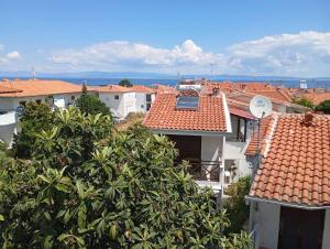 a view of roofs of buildings with a clock on the roof at Avraam Apartment Polychrono in Polychrono