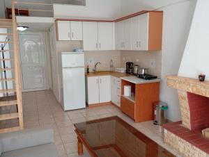 a kitchen with white cabinets and a white refrigerator at Avraam Apartment Polychrono in Polychrono