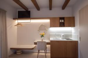eine kleine Küche mit Spüle und Spiegel in der Unterkunft ARGO Luxury Suites in Milína + 43 Fotos
