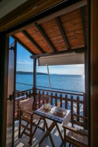 ein Tisch auf einem Balkon mit Blick auf das Meer in der Unterkunft ARGO Luxury Suites in Milína