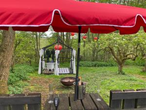 a red umbrella with a grill in a park at The Shangri La Sunset Yurt in Tenbury