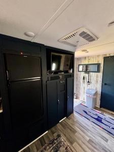 a living room with a black door and a tv at Hidden Anchor in Burton