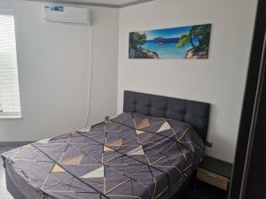 ein Schlafzimmer mit einem Bett und einem Bild an der Wand in der Unterkunft Dan-Mari in Baltschik