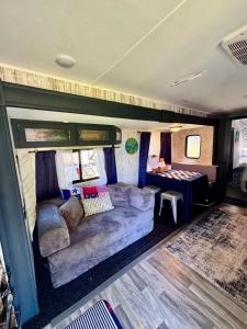 a living room in an rv with a couch at Hidden Anchor in Burton