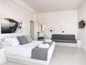 a white living room with a bed and a couch at Perissa Design Centro Suites- BEACH FRONT in Perissa