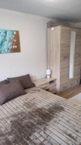 a bedroom with a bed and a painting on the wall at Napsugár Nyaraló in Tiszaalpár