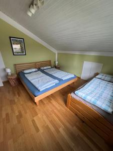 two beds in a room with green walls and wooden floors at Ferienwohnung Miesseler in Kall
