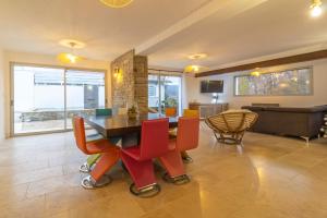 a dining room with a table and red chairs at villa avec piscine in Hendaye