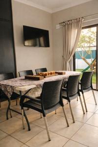 a dining room with a marble table and chairs at Garden Route Retreat in George