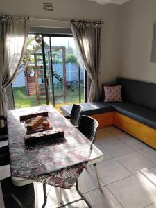 a living room with a table and a couch at Garden Route Retreat in George