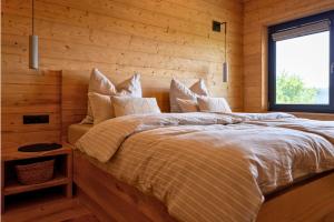 a bedroom with a large bed in a wooden wall at Bayerwald Chalet Liebenstein in Bad Koetzting