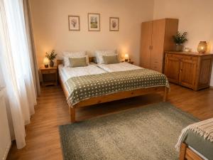 a bedroom with a bed and a dresser with two lamps at Zöld Vendégház in Csernely