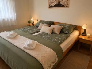 a bedroom with a bed with towels on it at Zöld Vendégház in Csernely